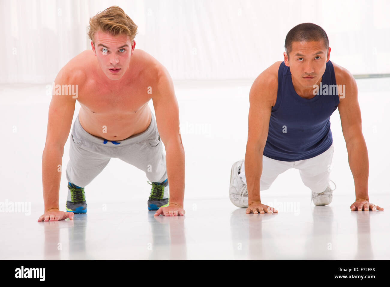 Deux jeunes man doing push-ups in gym Banque D'Images