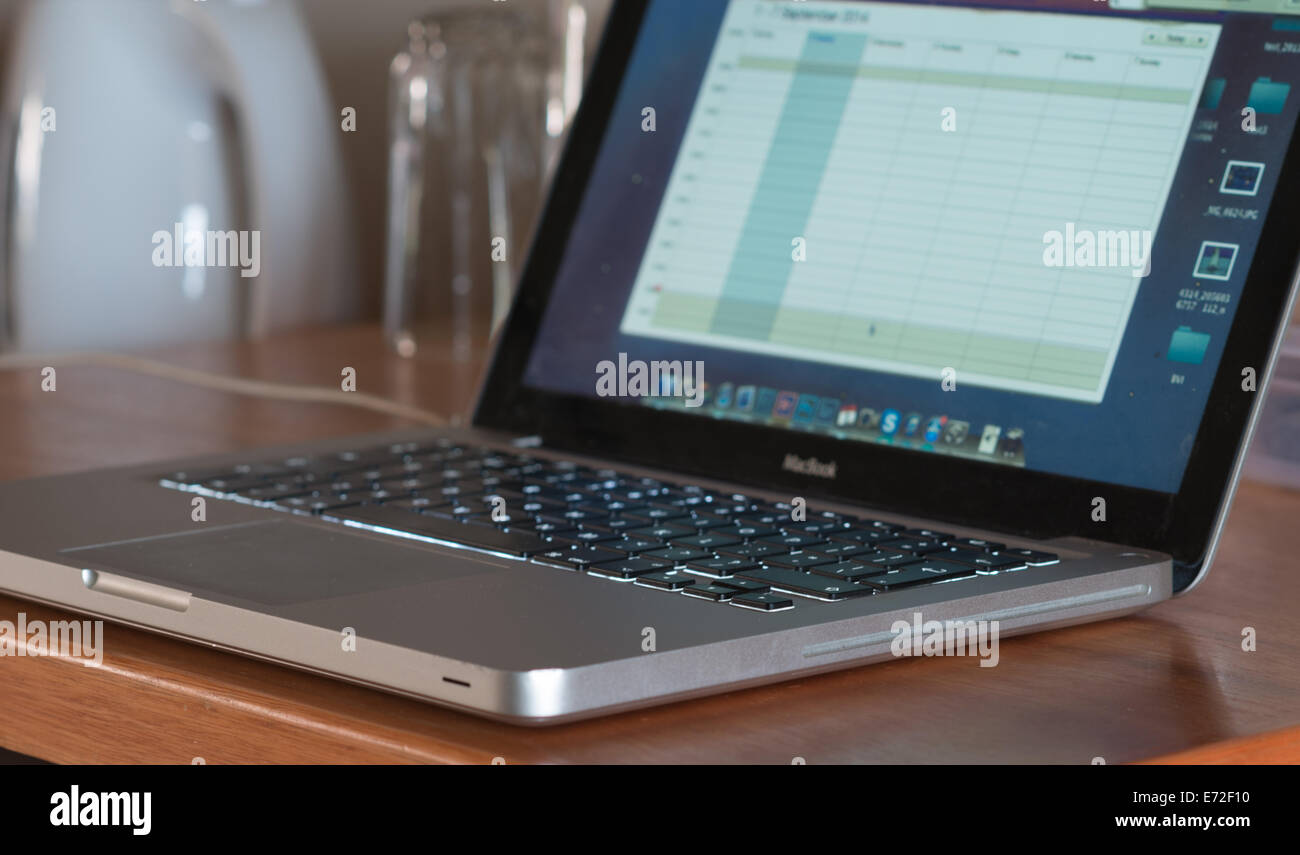 Le clavier éclairé d'un ordinateur portable Apple Macbook s'assit sur un bureau. Banque D'Images