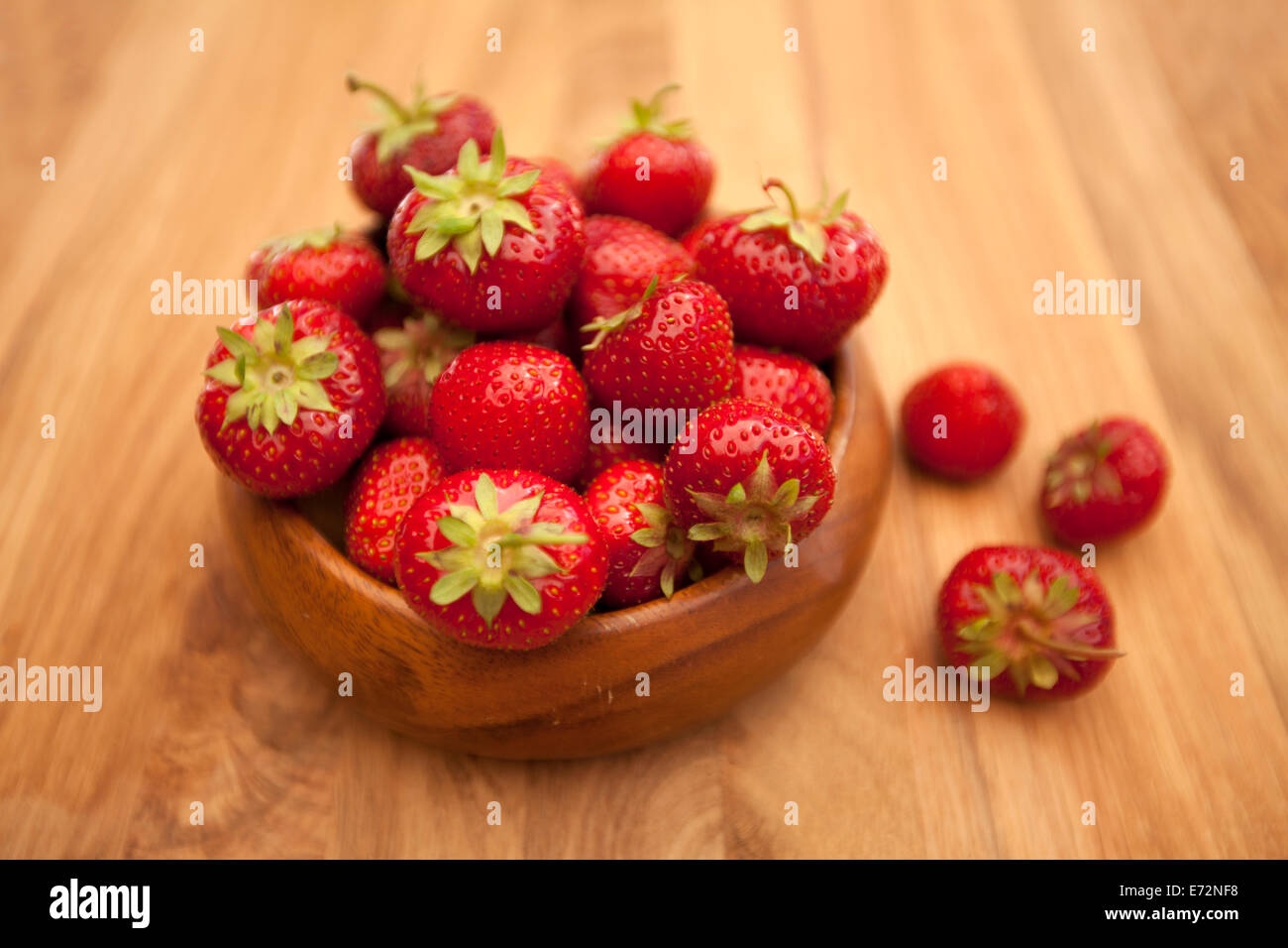 Fraises fraîches dans un bol sur la table en bois Banque D'Images