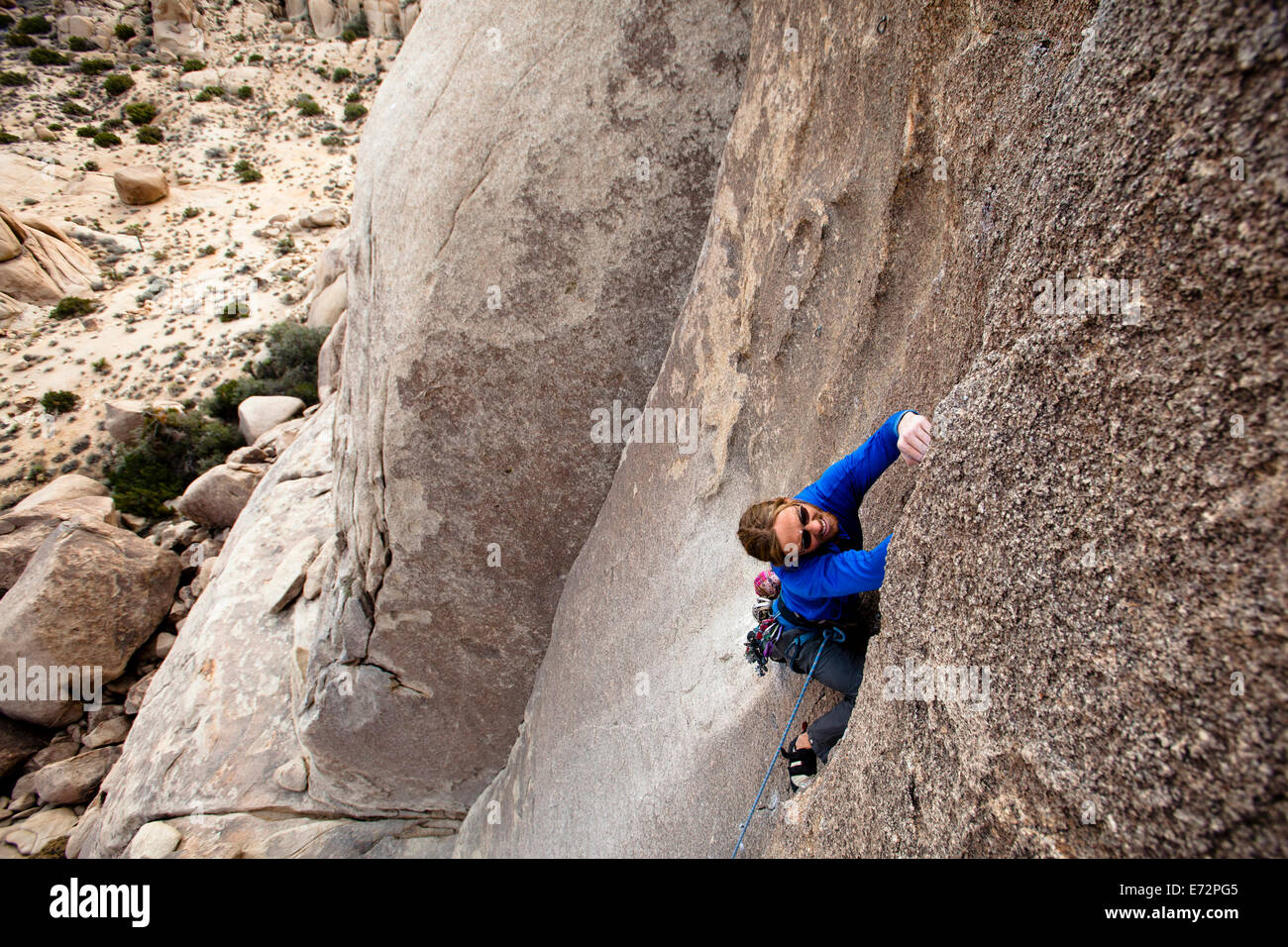 Un grimpeur mâle confitures son chemin jusqu'Oiseau de feu (5.10a) dans le parc national Joshua Tree, en Californie. Banque D'Images