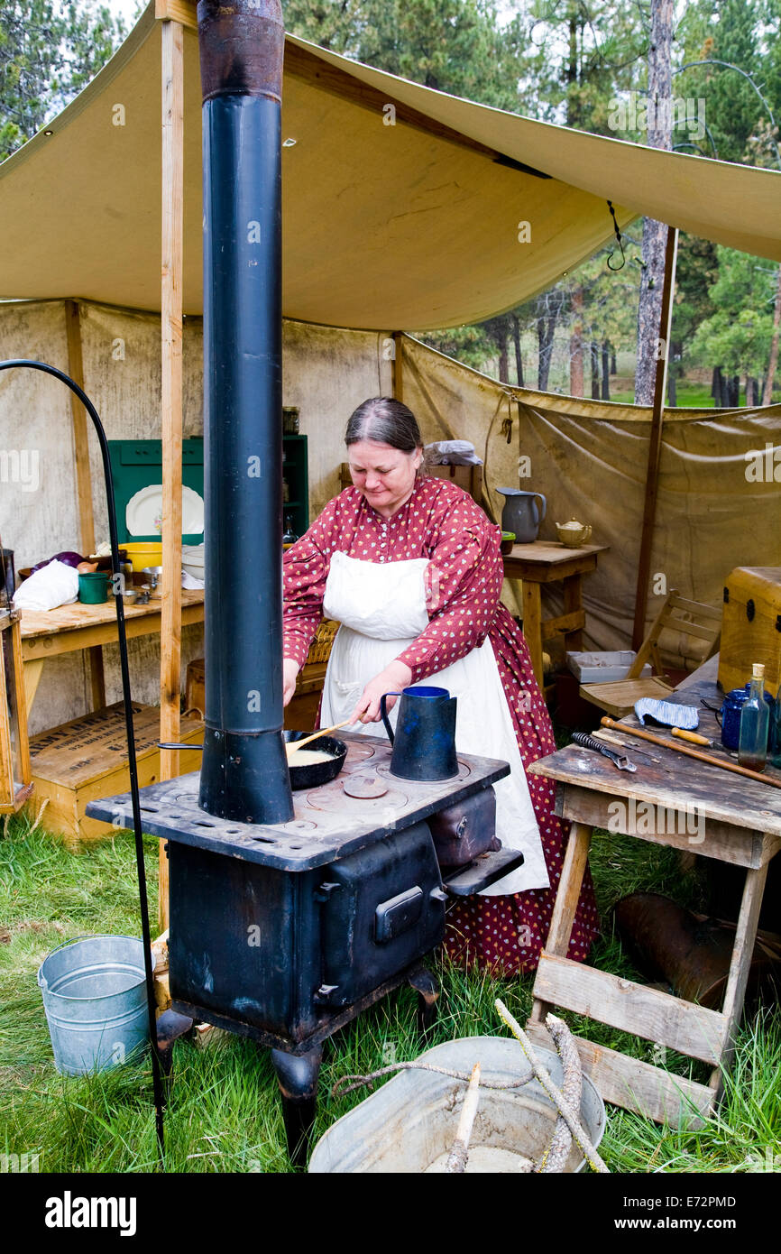 Une femme cuisine sur un poêle à bois au cours d'une reconstitution de la guerre civile entre le nord et le sud de soldats détenus dans la région de la rivière Metolius dans le centre de l'Oregon. Banque D'Images