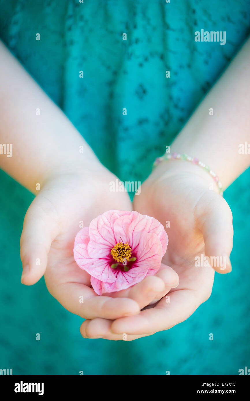 Teenage girl (13-15) avec une fleur dans la main Banque D'Images