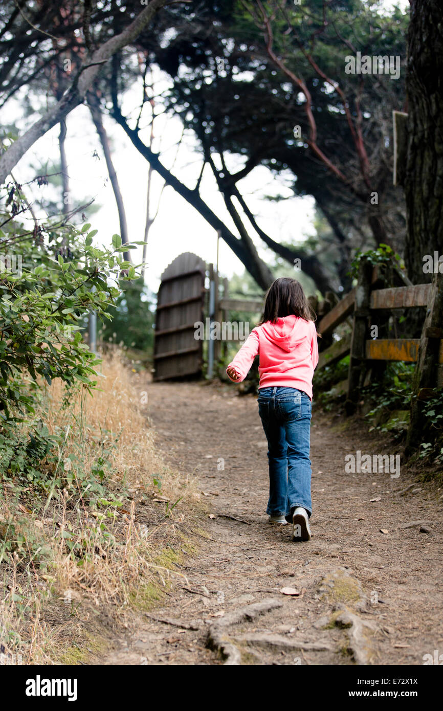 Vue arrière du girl (6-7) walking route de terre Banque D'Images