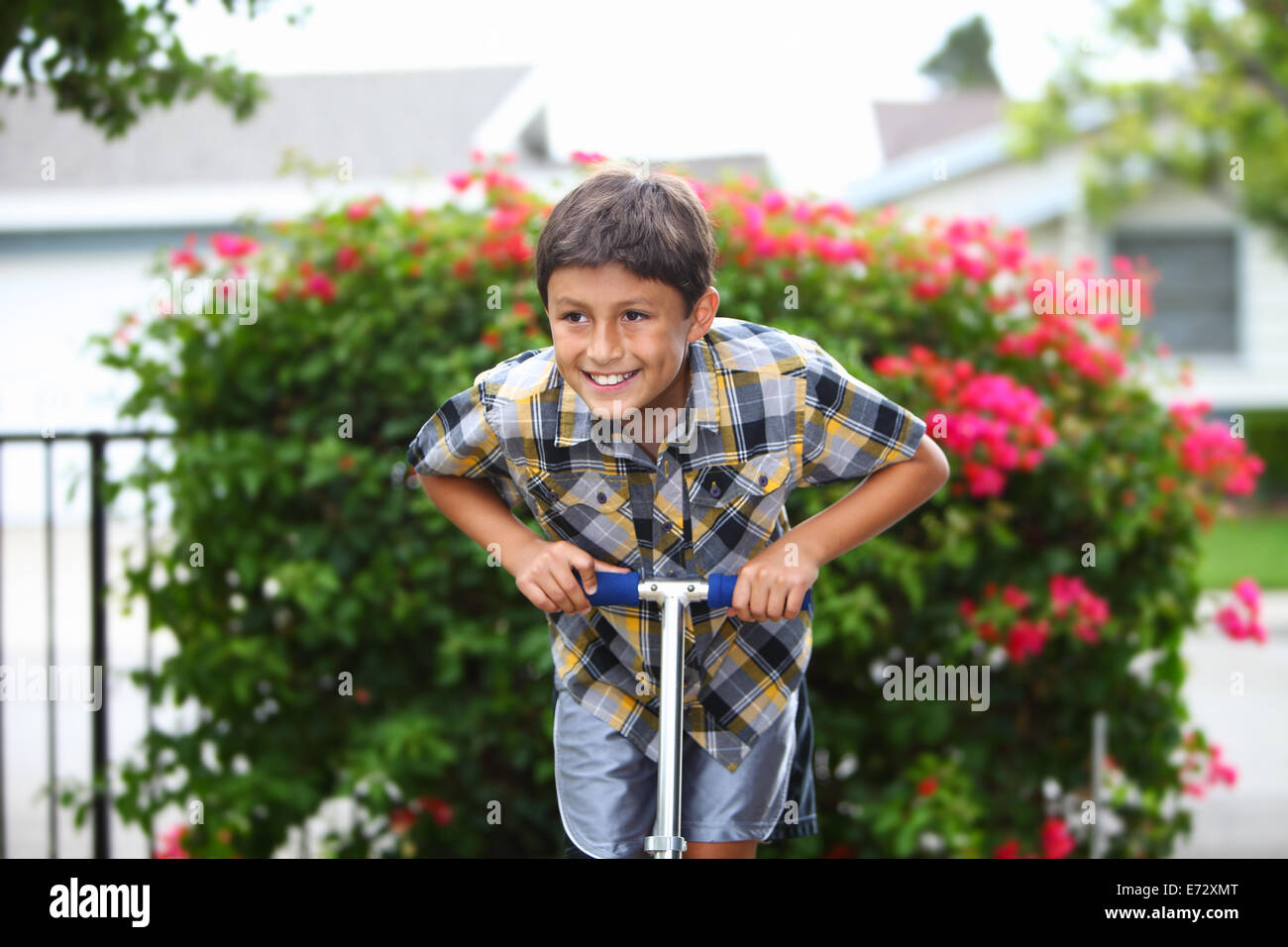 Jeune garçon jouant sur un scooter Banque D'Images