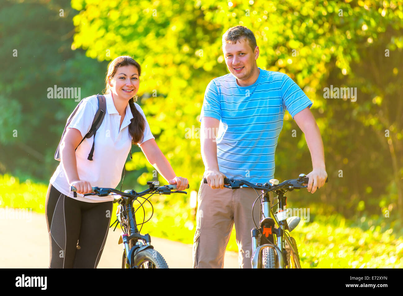 Jeune couple sur le week-end à faire du vélo dans le parc Banque D'Images