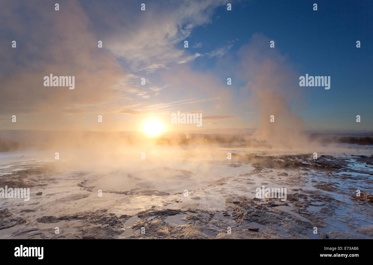 L'augmentation de vapeur géothermique de piscines au lever du soleil en hiver, Geysir, Haukardalur Valley, l'Islande, les régions polaires Banque D'Images