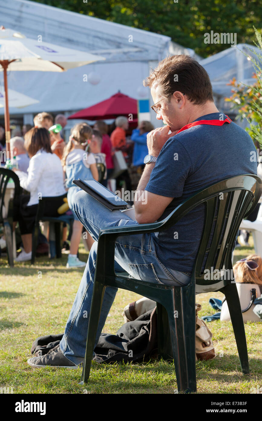 Un visiteur lit un e-livre le jour de l'ouverture de l'Edinburgh International Book Festival 2014. Edimbourg, Ecosse. 9 Août Banque D'Images