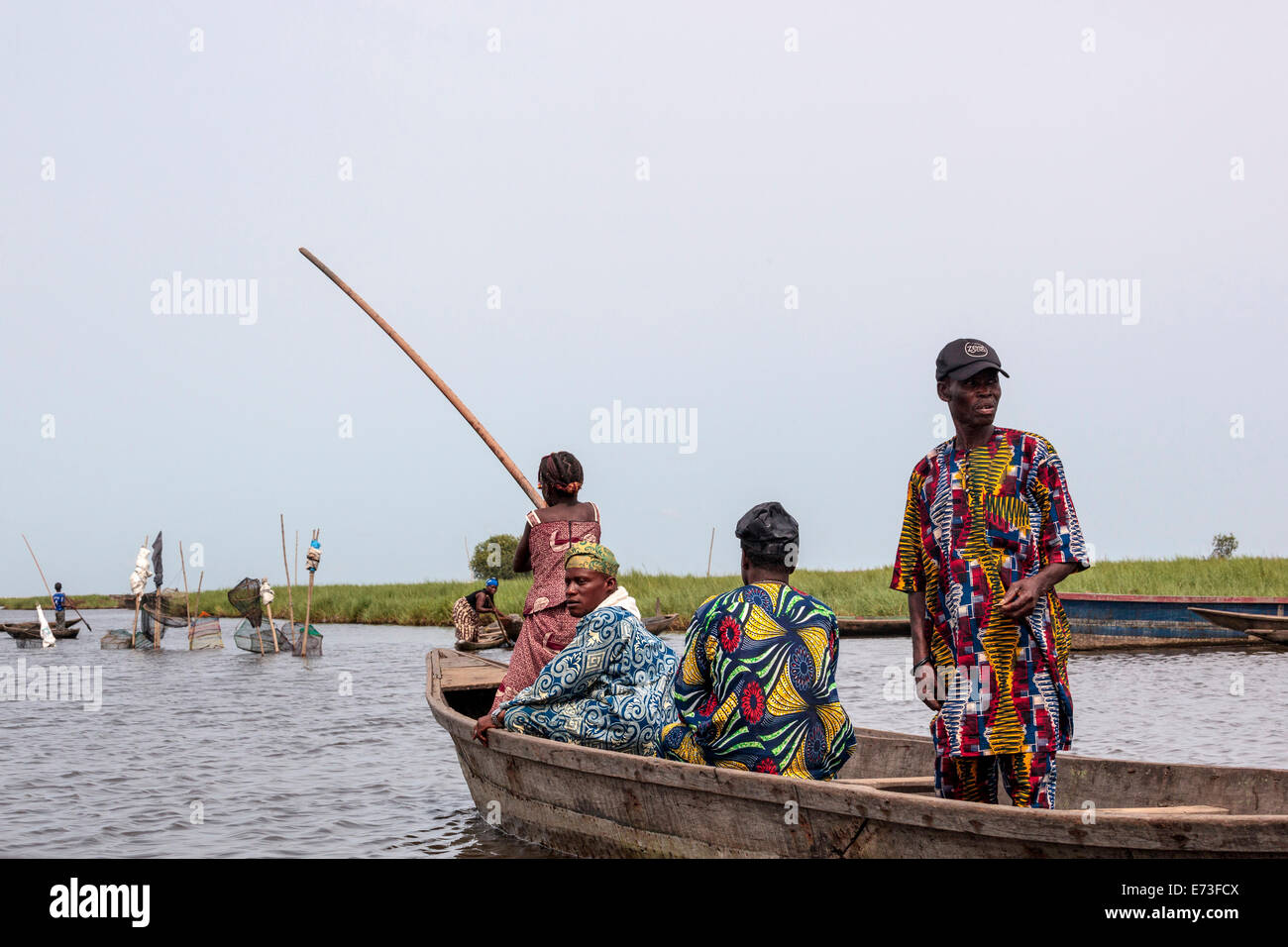L'Afrique, Bénin, Ganvie. Habillés de couleurs vives de passagers en pirogue. Banque D'Images