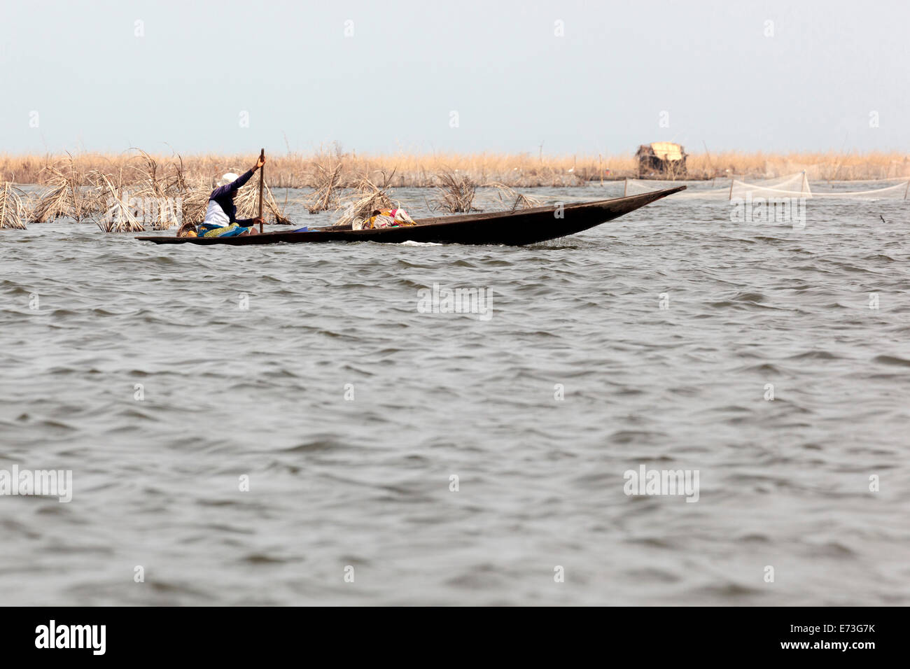 L'Afrique, Bénin, Ganvie. Woman paddling de pirogue sur le Lac Nokoué. Banque D'Images