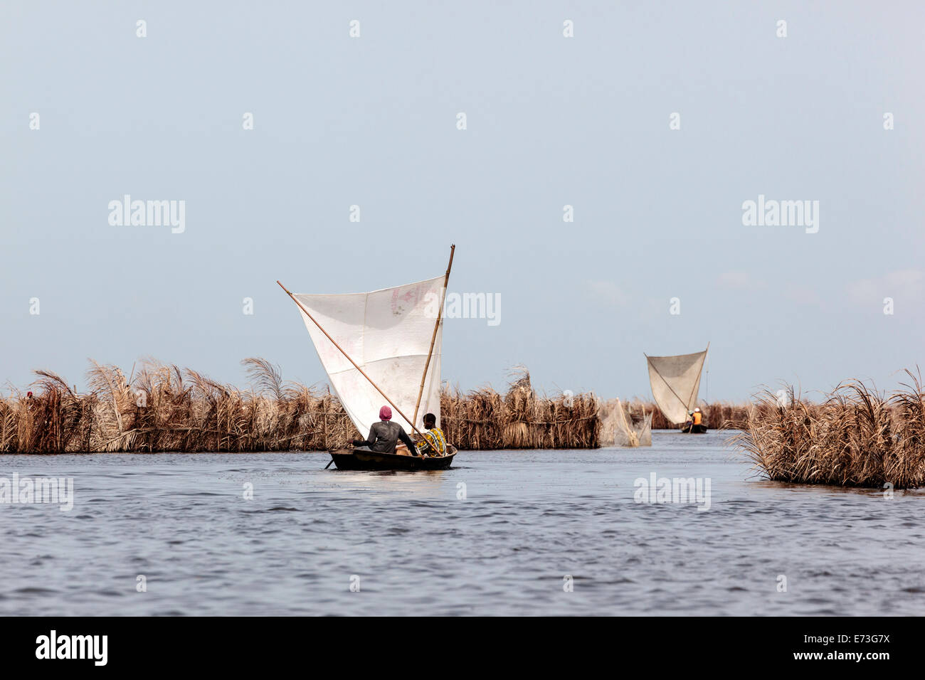 L'Afrique, Bénin, Ganvie. Les hommes pirogues traditionnelles de voile sur le Lac Nokoué. Banque D'Images
