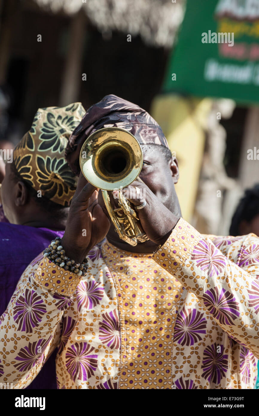 L'Afrique, Bénin, Ganvie. L'homme en costume traditionnel à jouer de la trompette. Banque D'Images