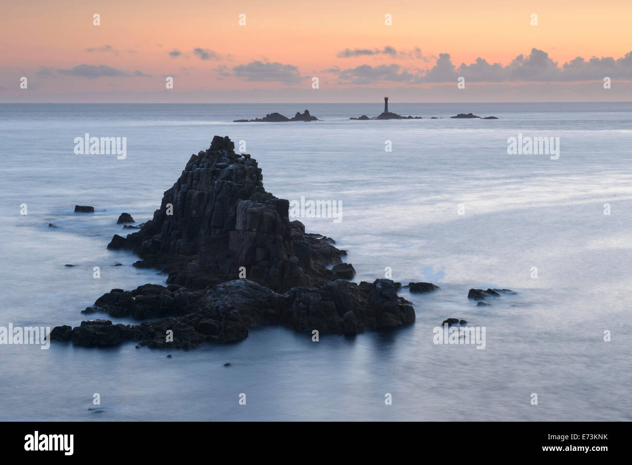 L'île rocheuse connue sous le nom de chevalier armé avec Phare drakkars au loin, au large de la côte de Land's End, Cornwall. Banque D'Images