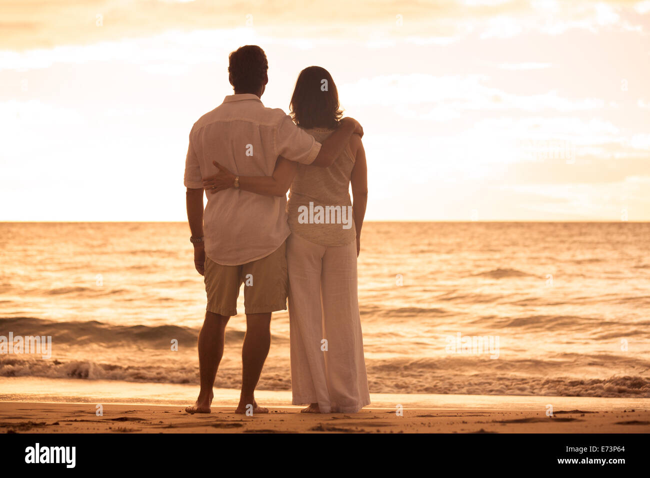 Mature Couple romantique au coucher du soleil sur la plage à Hawaii Banque D'Images