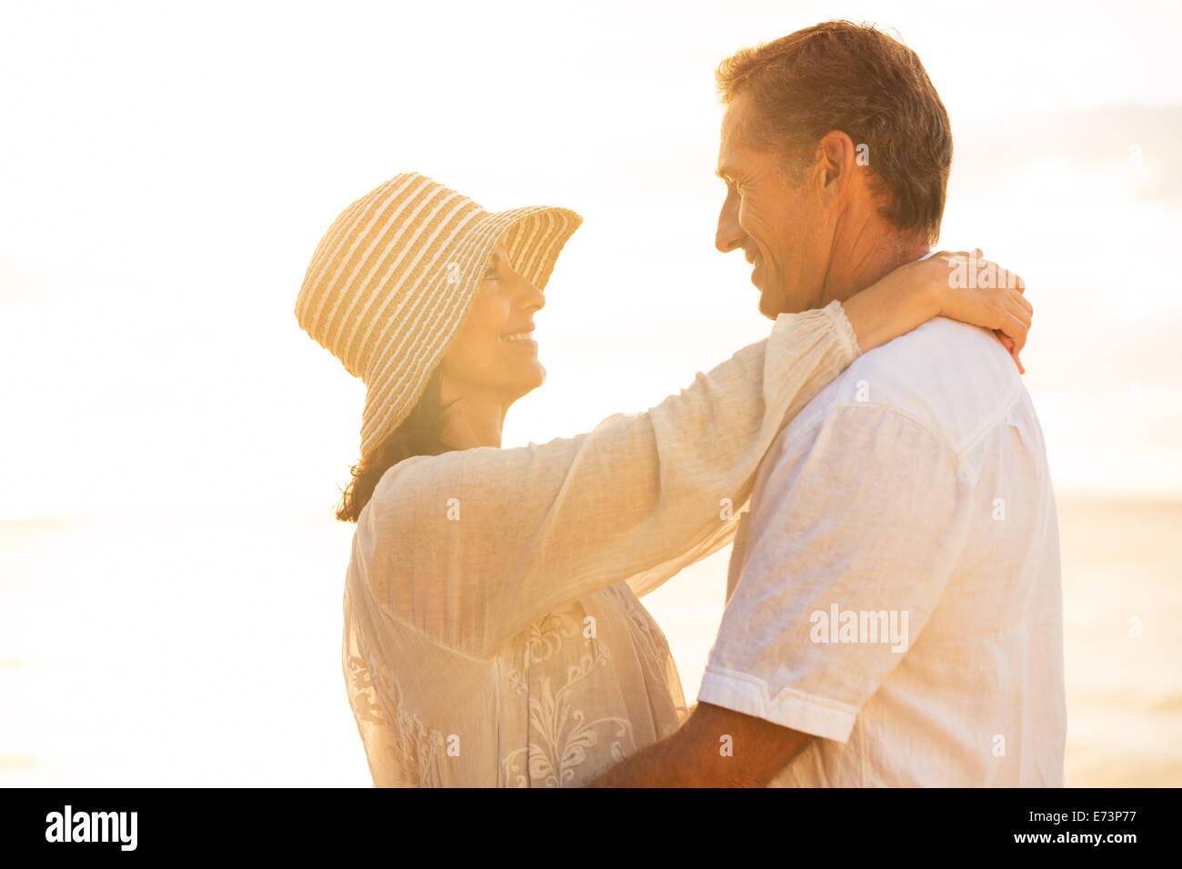 Happy Young Couple in Love sur la plage au coucher du soleil Banque D'Images