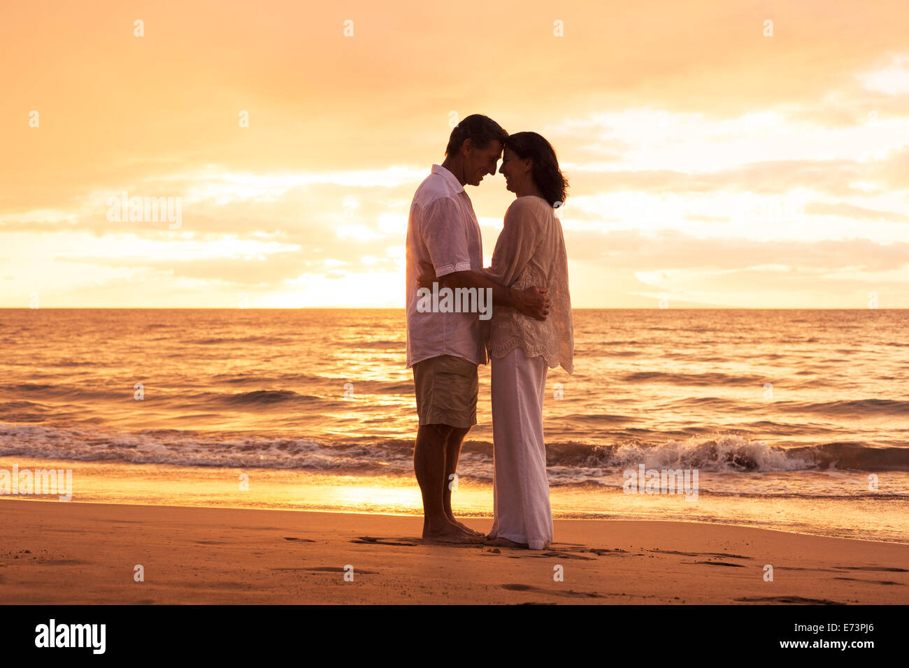 Couple romantique dans l'amour embrassant sur la plage au coucher du soleil Banque D'Images