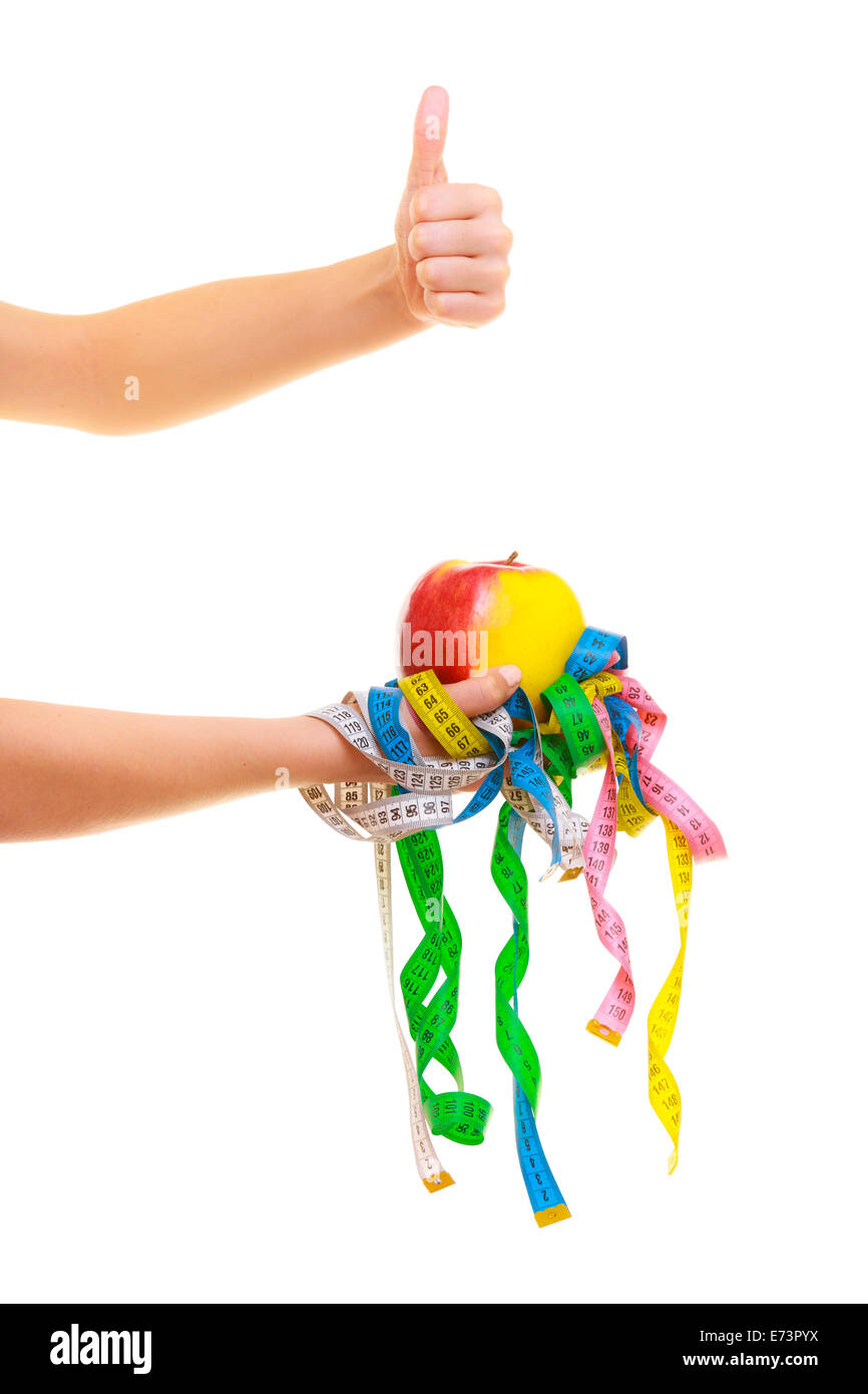 Minceur régime perte de poids. Soins de santé et d'une alimentation saine. Libre de rubans colorés et de mesurer les fruits apple dans une main de femme Banque D'Images