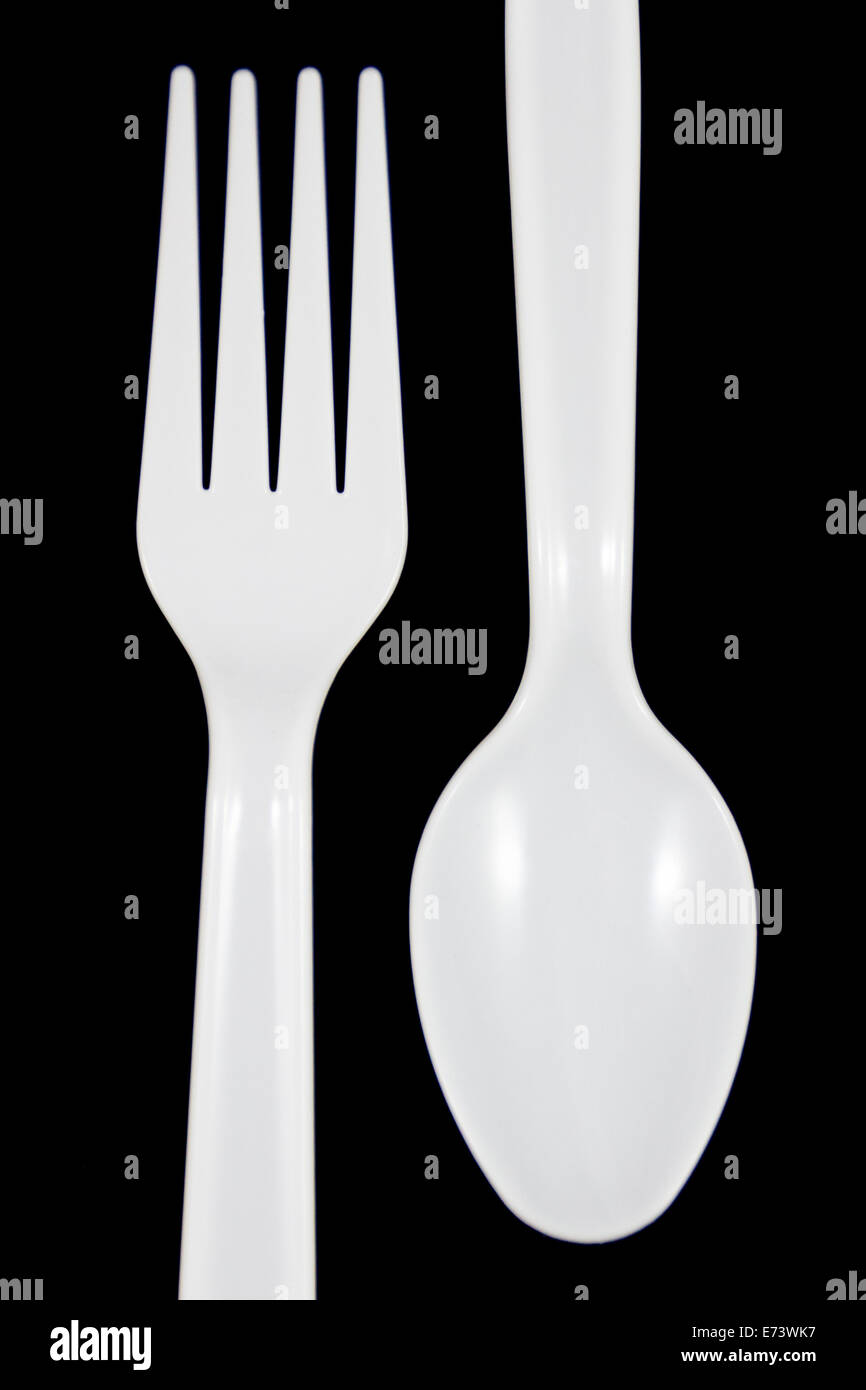 Fourchette et cuillère en plastique blanc sur fond noir. Banque D'Images