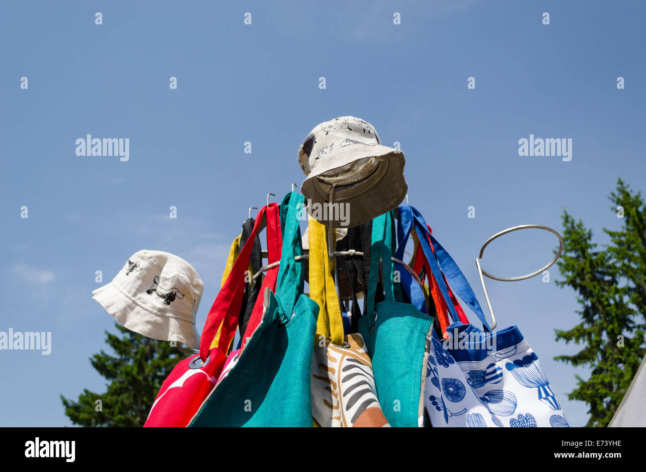 Coudre à la main le linge des casquettes et sac sur le stand sur fond de ciel bleu Banque D'Images