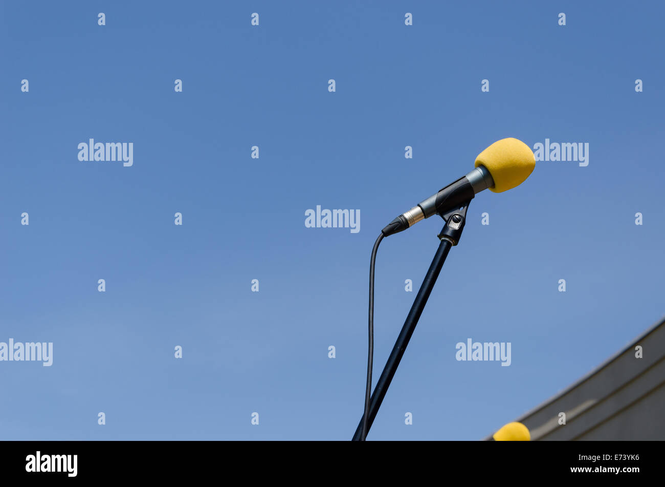 Microphone avec support jaune sur fond de ciel bleu Banque D'Images