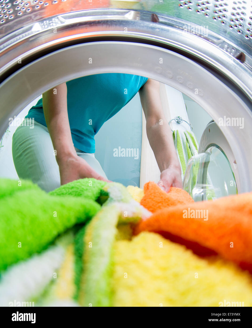 Femme de ménage vêtements chargement en lave-linge Banque D'Images