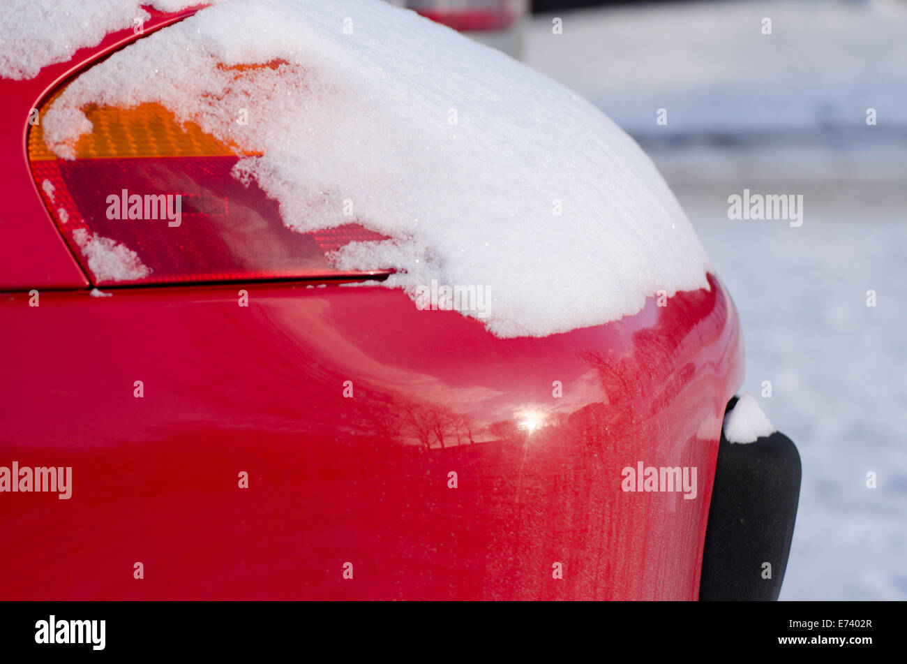 Voiture rouge feu avant recouverte de neige poudreuse par temps froid l'hiver Banque D'Images
