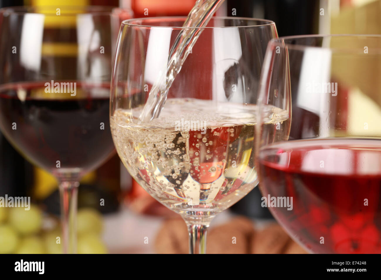 Le vin blanc et verser dans un verre de vin. Selective focus sur le vin blanc. Banque D'Images