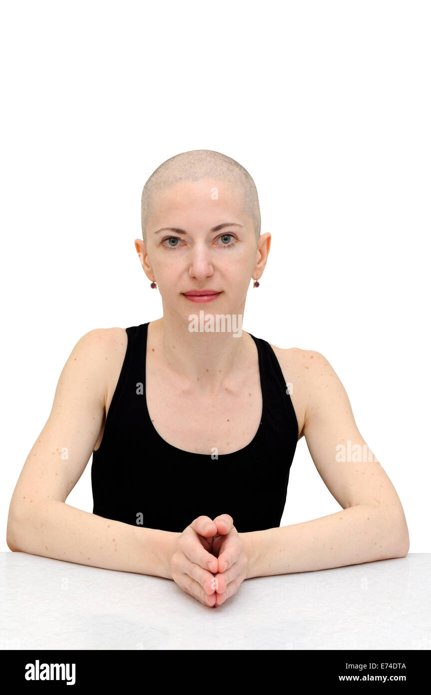Bald Woman in Black T-shirt détendu, assis à une table, les paumes jointes. Isolé avec chemin de détourage. Banque D'Images