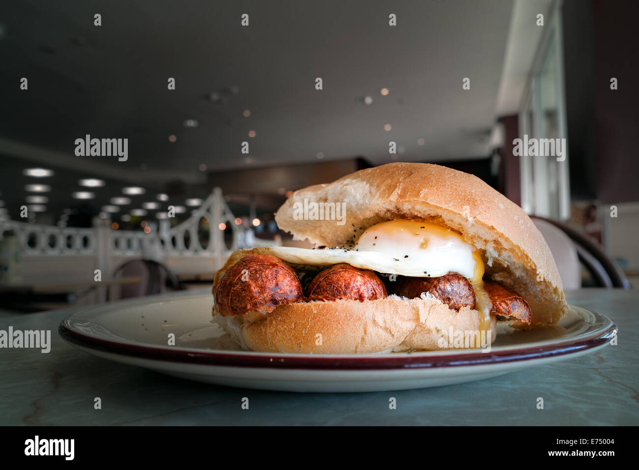 Rouleau de saucisses et de petit-déjeuner sur un plateau d'oeufs à une table dans un cafe Banque D'Images