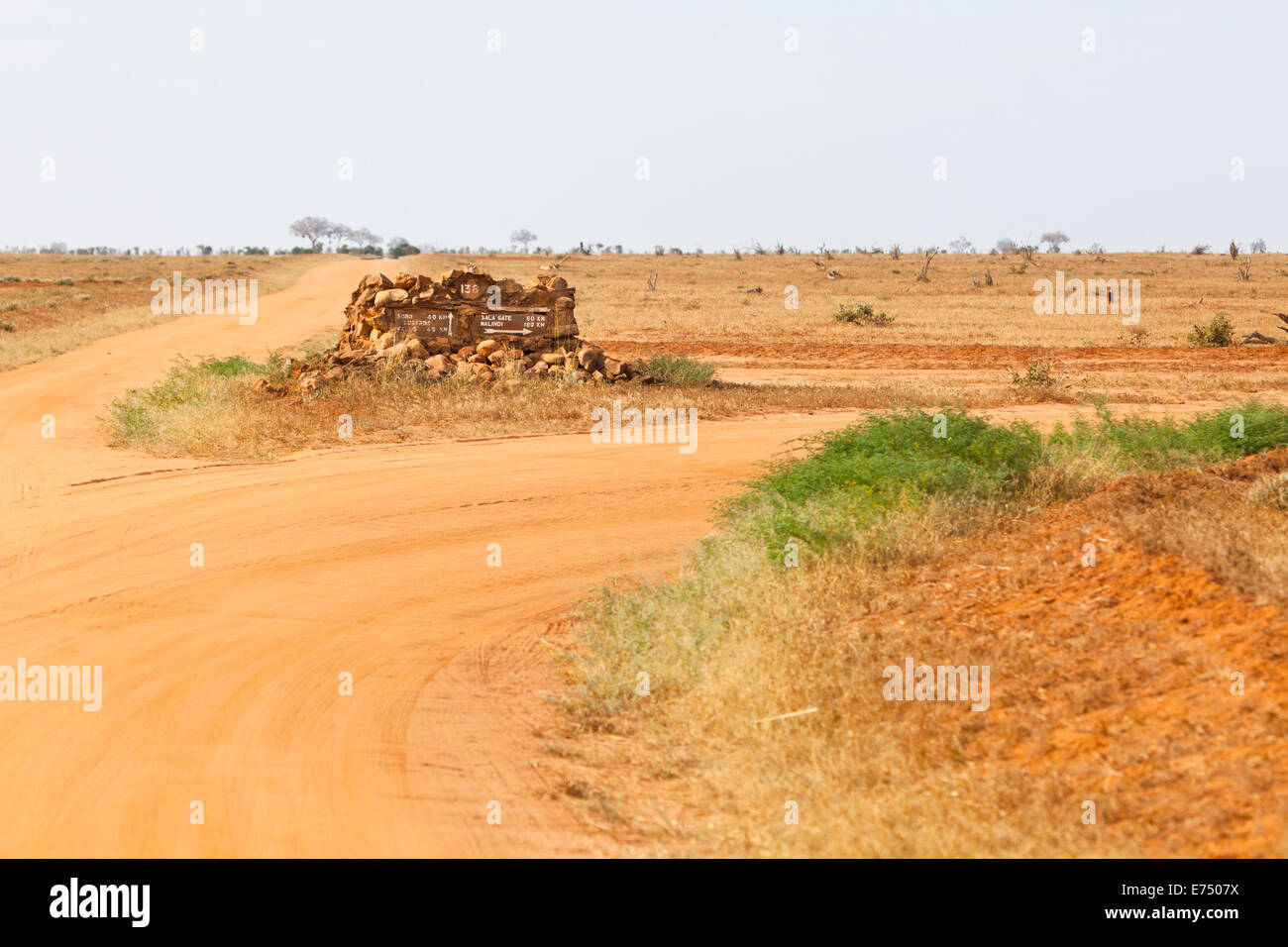 Paysage dans le parc national de Tsavo East au Kenya avec un panneau routier. Banque D'Images
