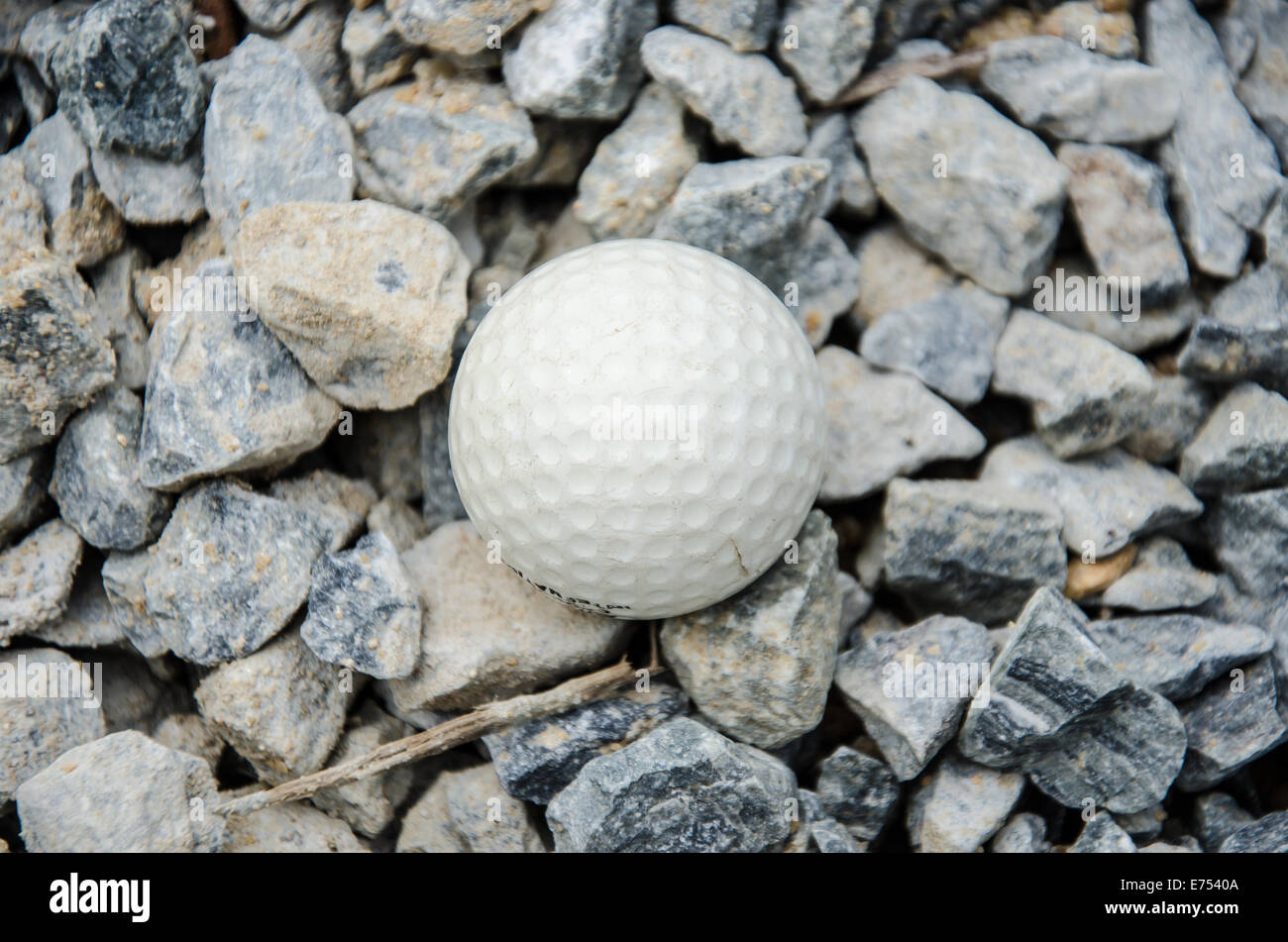 Balle de golf blanche sur le rocher Banque D'Images