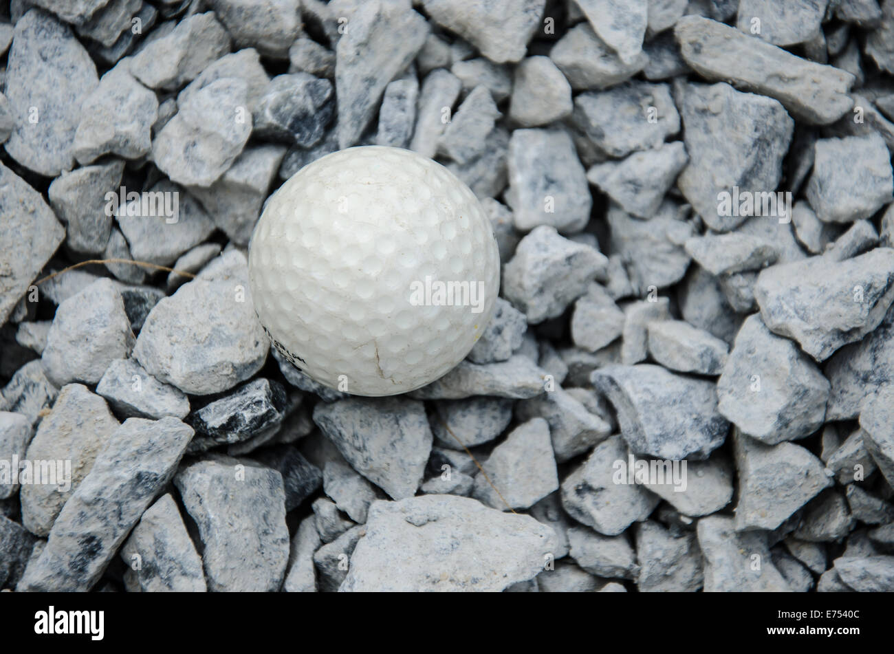 Balle de golf blanche sur le rocher Banque D'Images