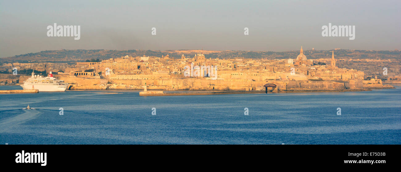 Au cours de la lumière du soleil tôt le matin d'or croisière Méditerranée approche pour La Valette avec le soleil sur le bord de bâtiments du Grand Port de Malte Banque D'Images