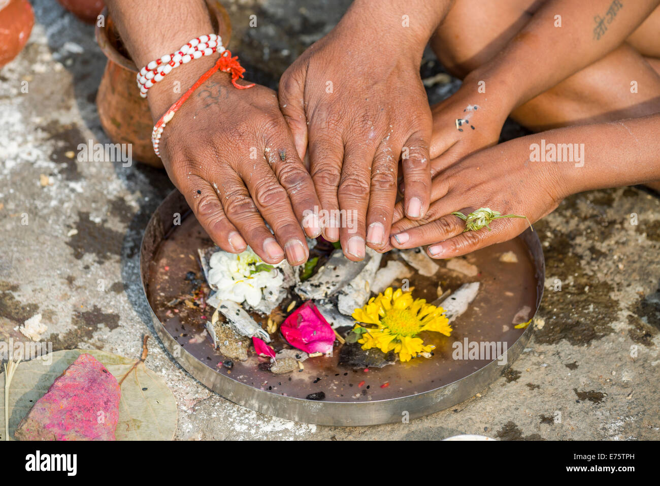 Les mains d'un homme et un garçon sont placés au-dessus des ossements Dashkriya ou Asthi Visarjan pendant, un rituel qui est effectuée 10 jours Banque D'Images