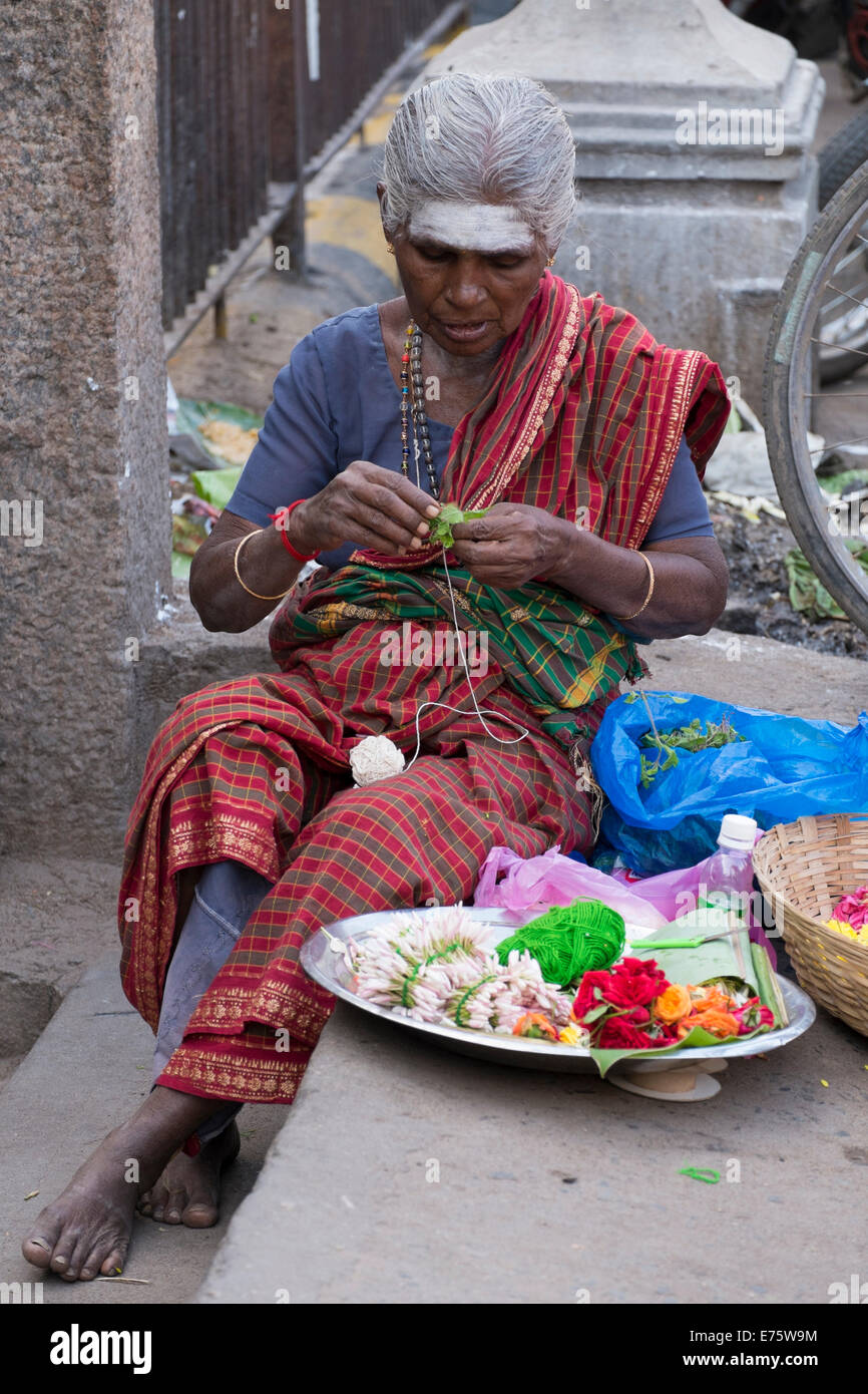 Femme de marché la production de décorations florales, Madurai, Tamil Nadu, Inde Banque D'Images