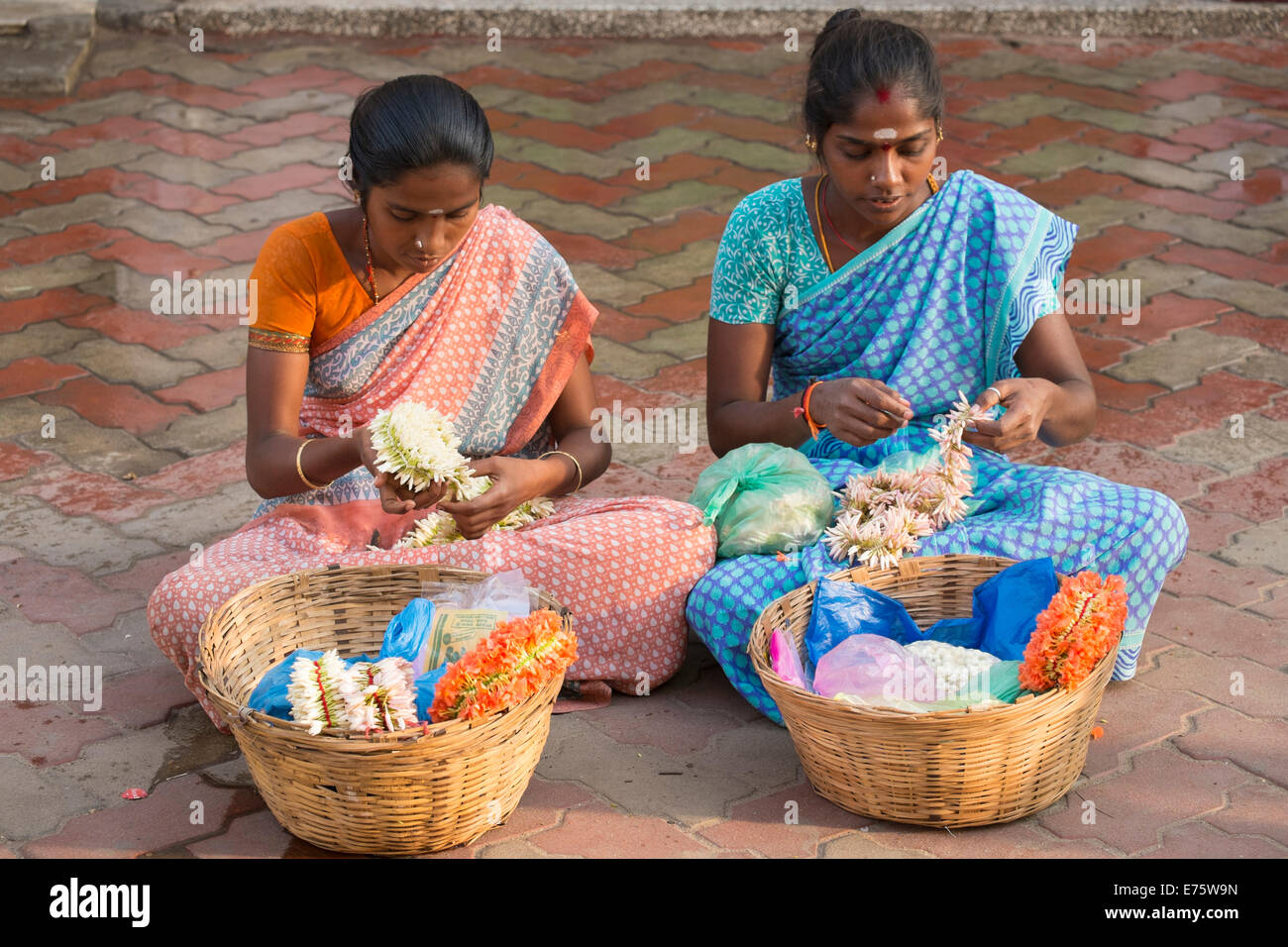 Deux filles produisant des décorations florales pour les vendre plus tard, Madurai, Tamil Nadu, Inde Banque D'Images