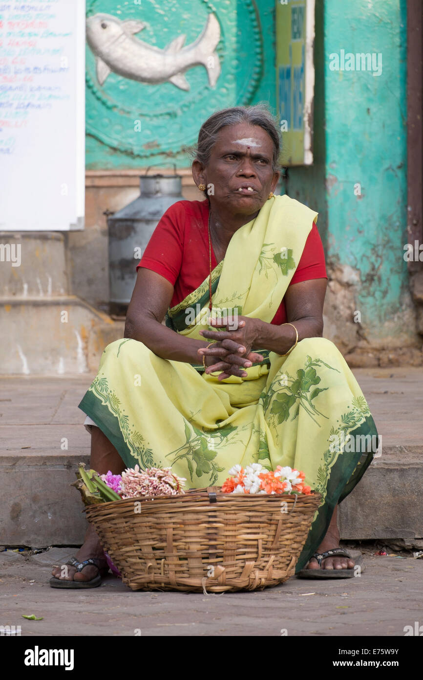 Femme assise devant un temple vente de décorations florales, Madurai, Tamil Nadu, Inde Banque D'Images