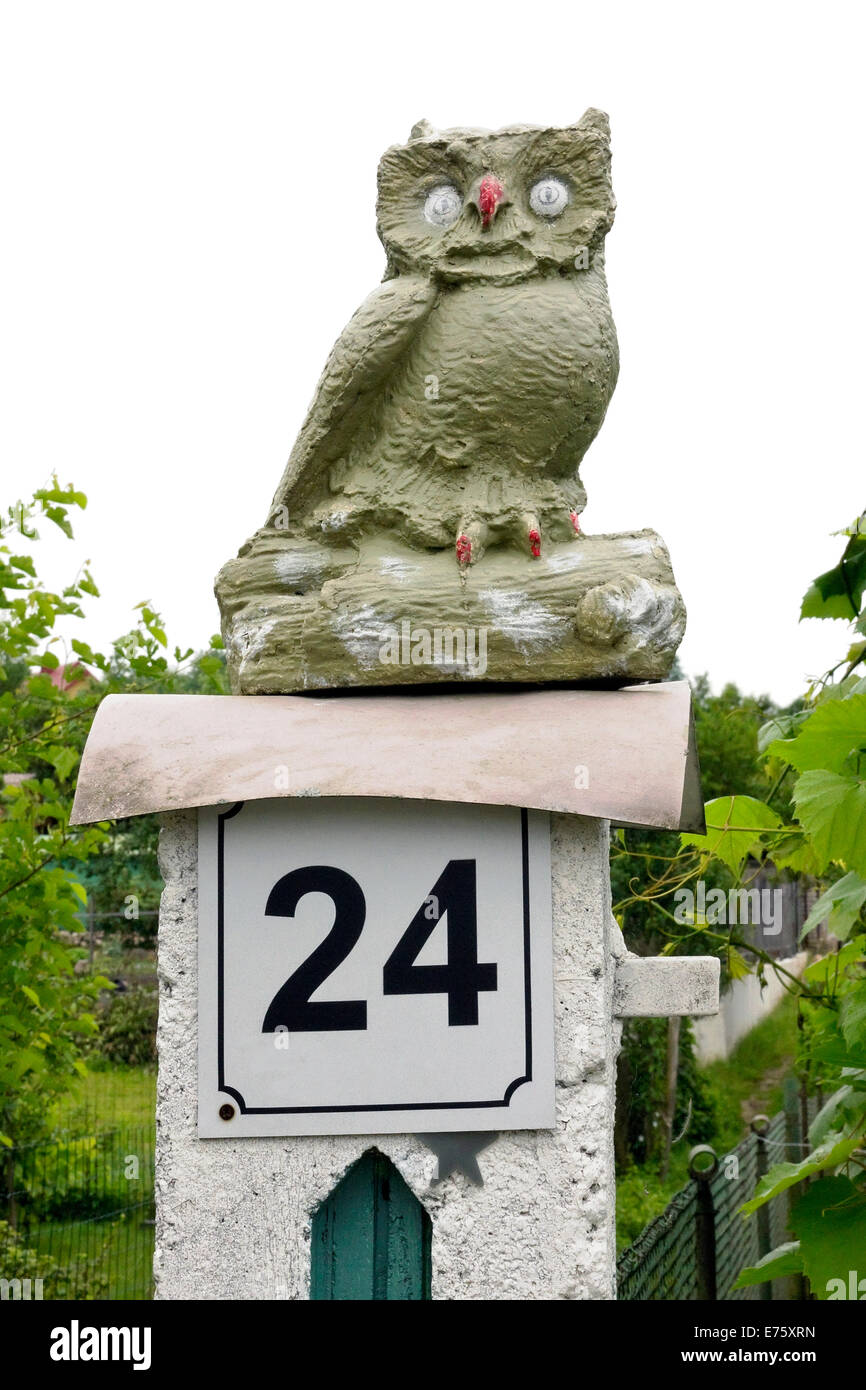La main de Pierre est assis sur un hibou naïf près de la colonne d'un jardin. Isolé Banque D'Images