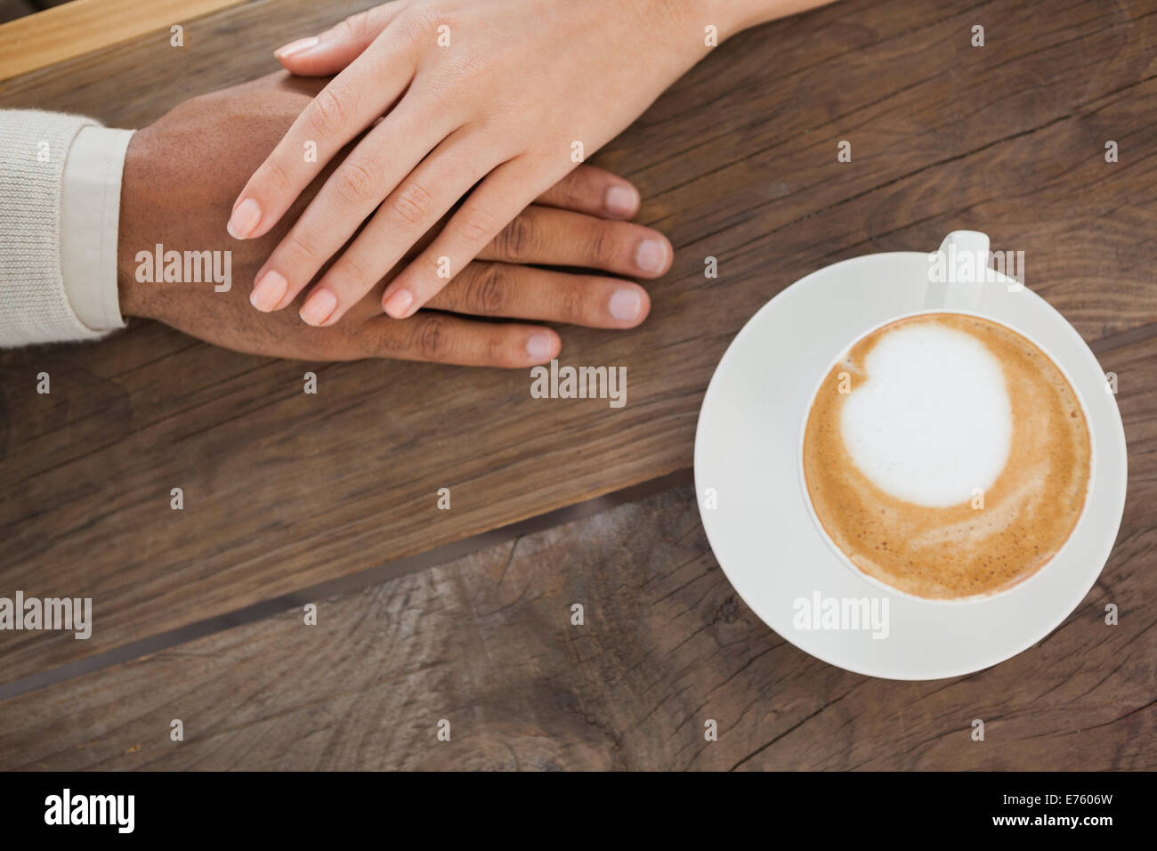 Couple holding hands à côté de cappuccino Banque D'Images