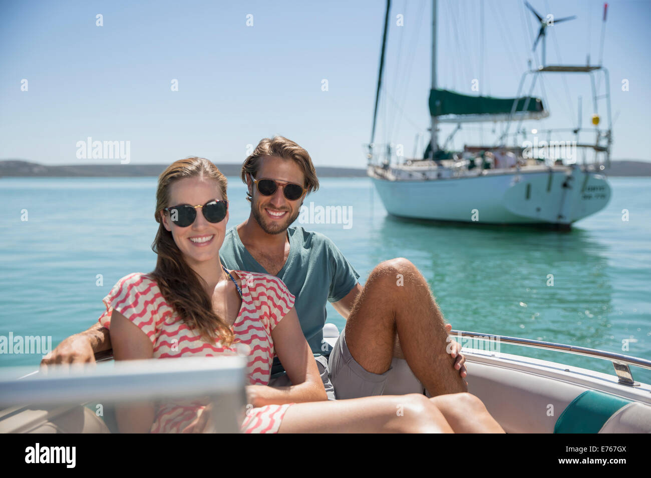 Couple assis dans un bateau sur l'eau Banque D'Images