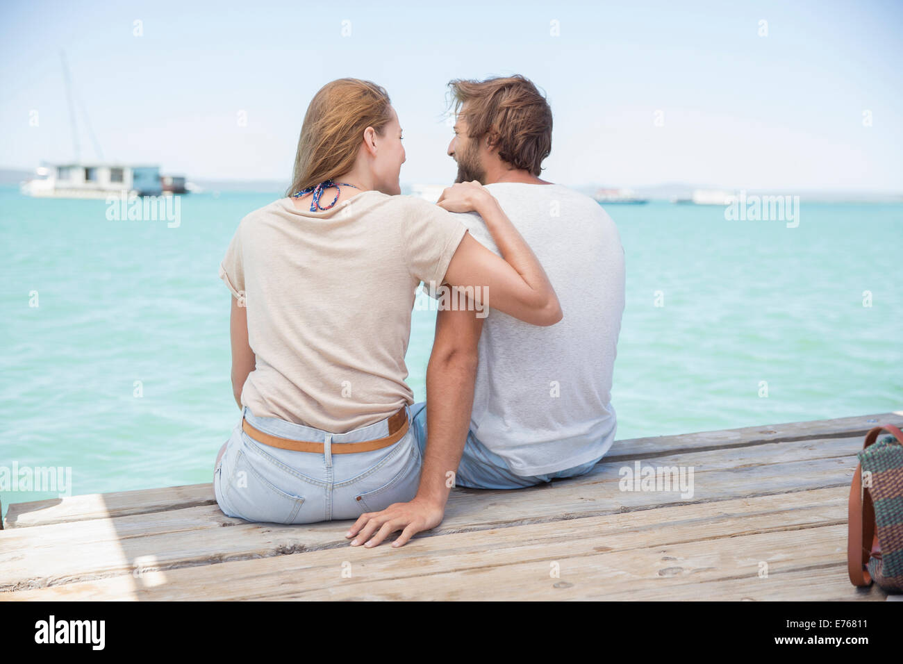 Couple assis sur le bord du quai en bois ensemble Banque D'Images