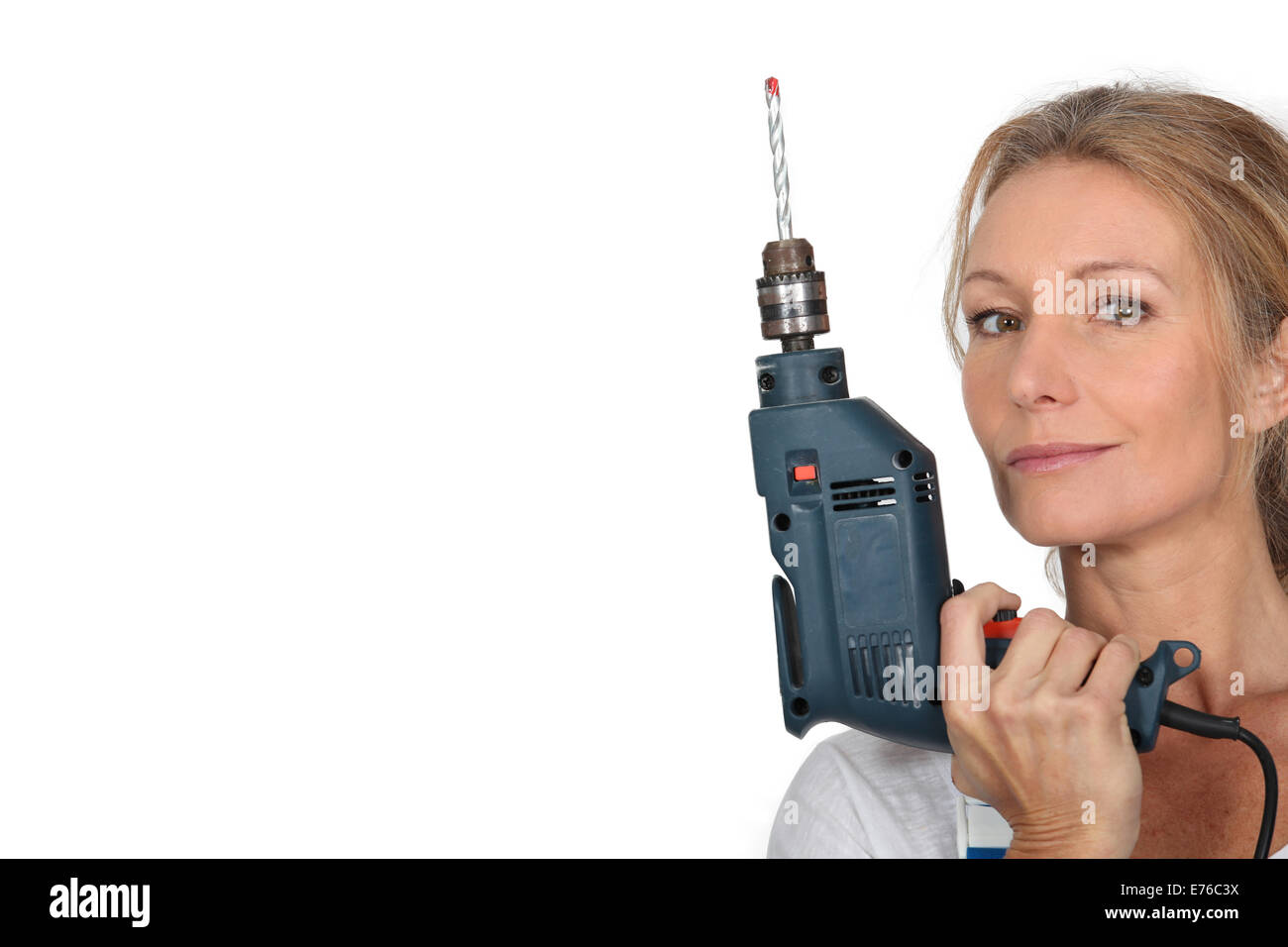 Blond woman holding electric drill Banque D'Images