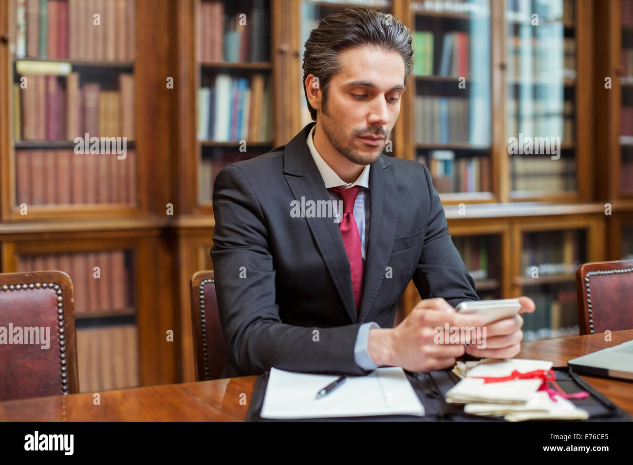 Juriste travaillant sur téléphone cellulaire en chambres Banque D'Images