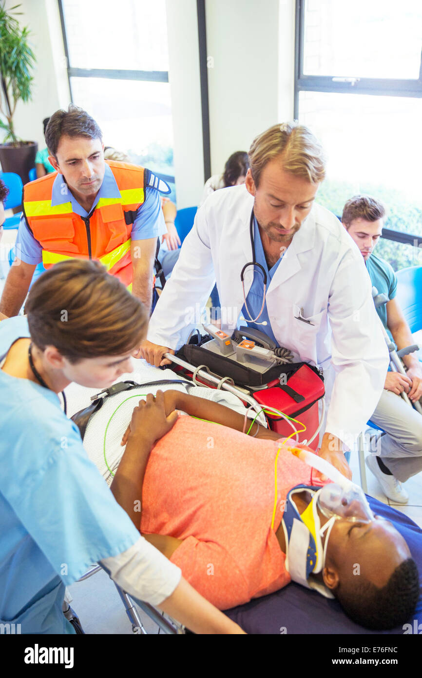 Médecin, infirmier et paramédicaux, wheeling patient in hospital Banque D'Images