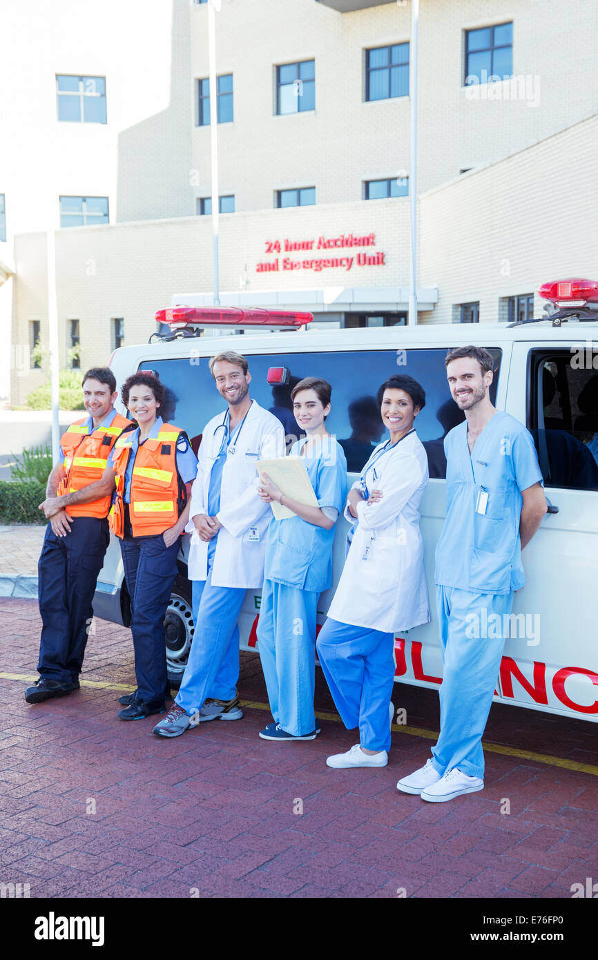Médecins, infirmières et ambulanciers paramédicaux smiling par ambulance Banque D'Images