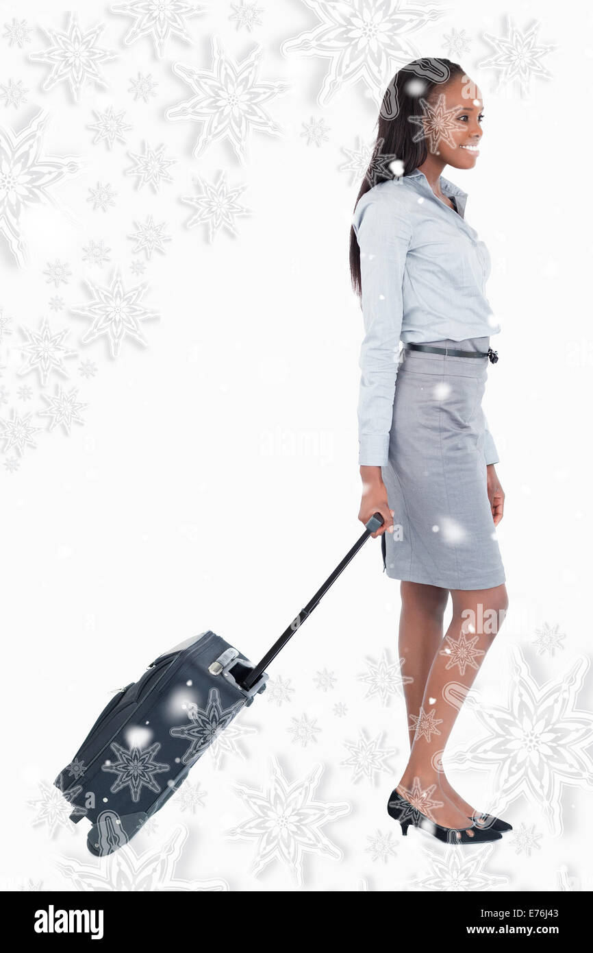Composite image of businesswoman walking with a suitcase Banque D'Images
