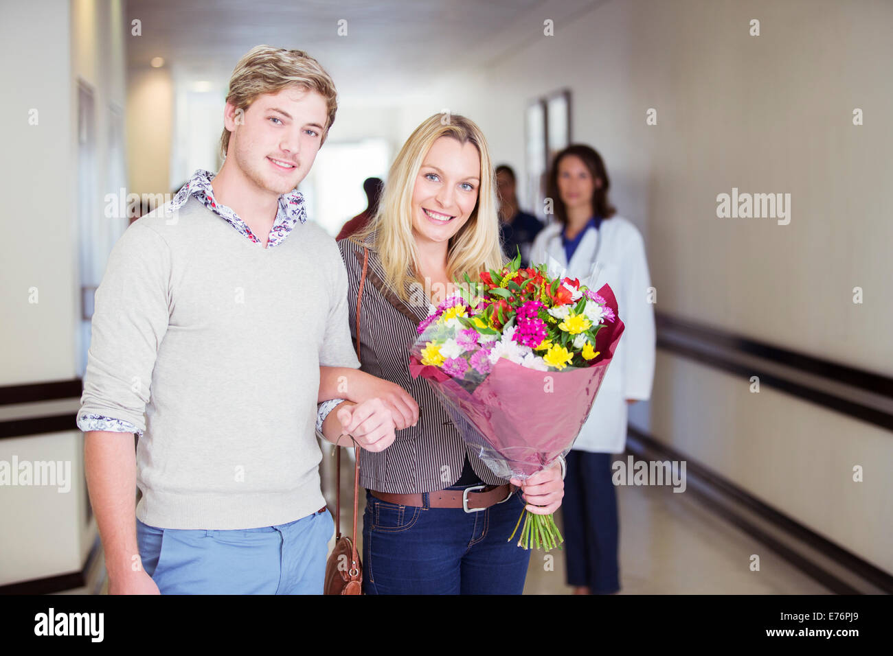 Couple carrying bouquet de fleurs à l'hôpital Banque D'Images