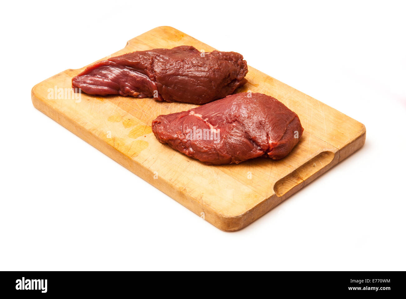 La viande de kangourou crus steaks sur un billot de bois, isolé sur un fond blanc studio. Banque D'Images