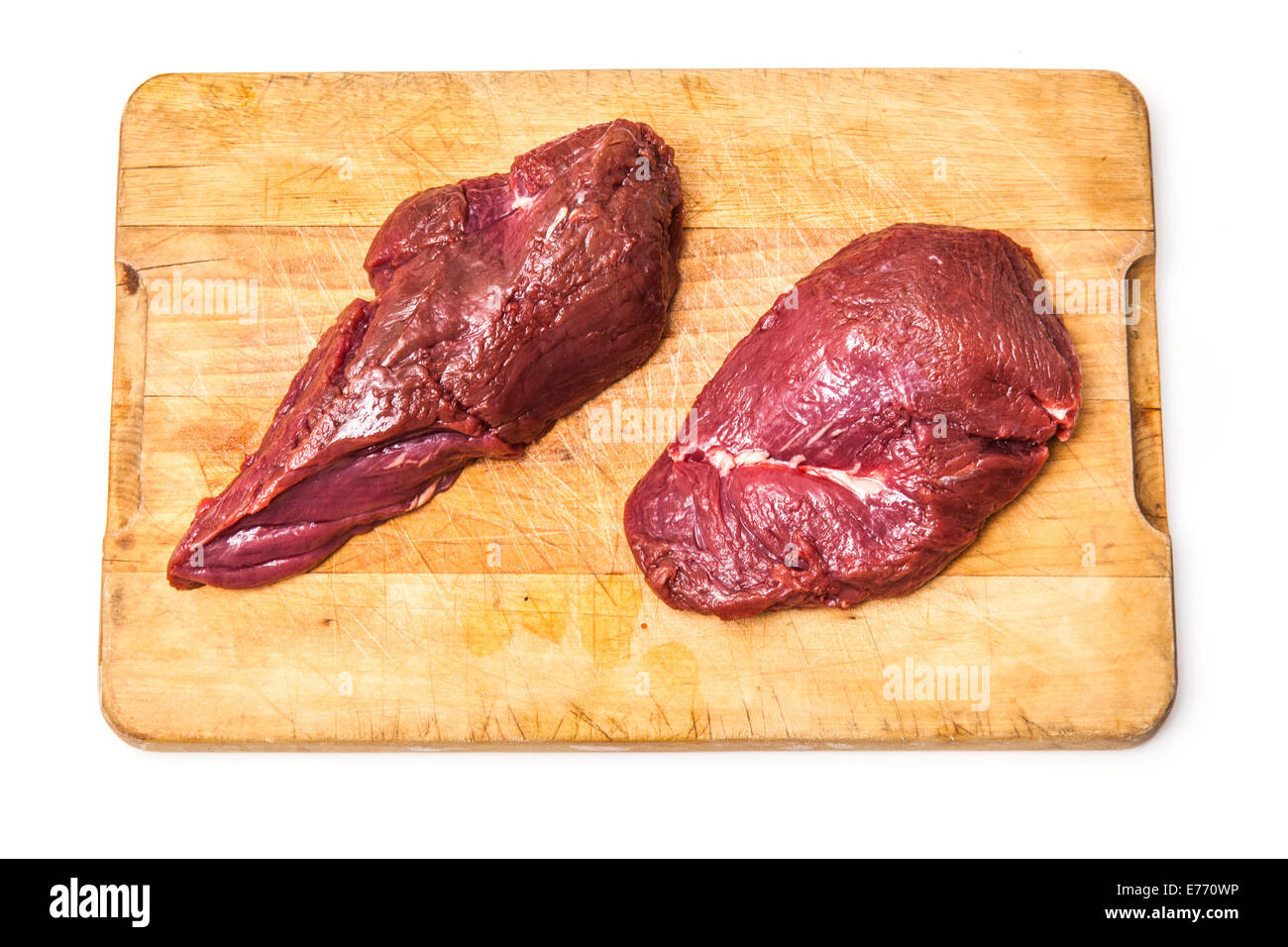 La viande de kangourou crus steaks sur un billot de bois, isolé sur un fond blanc studio. Banque D'Images