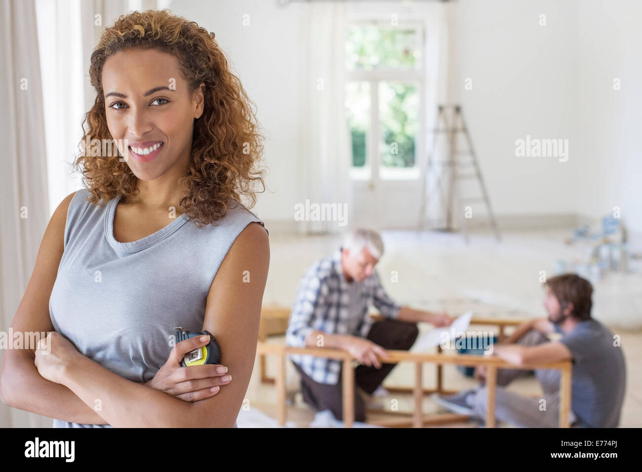 Woman smiling in vivant dans l'espace de travail de la famille Banque D'Images