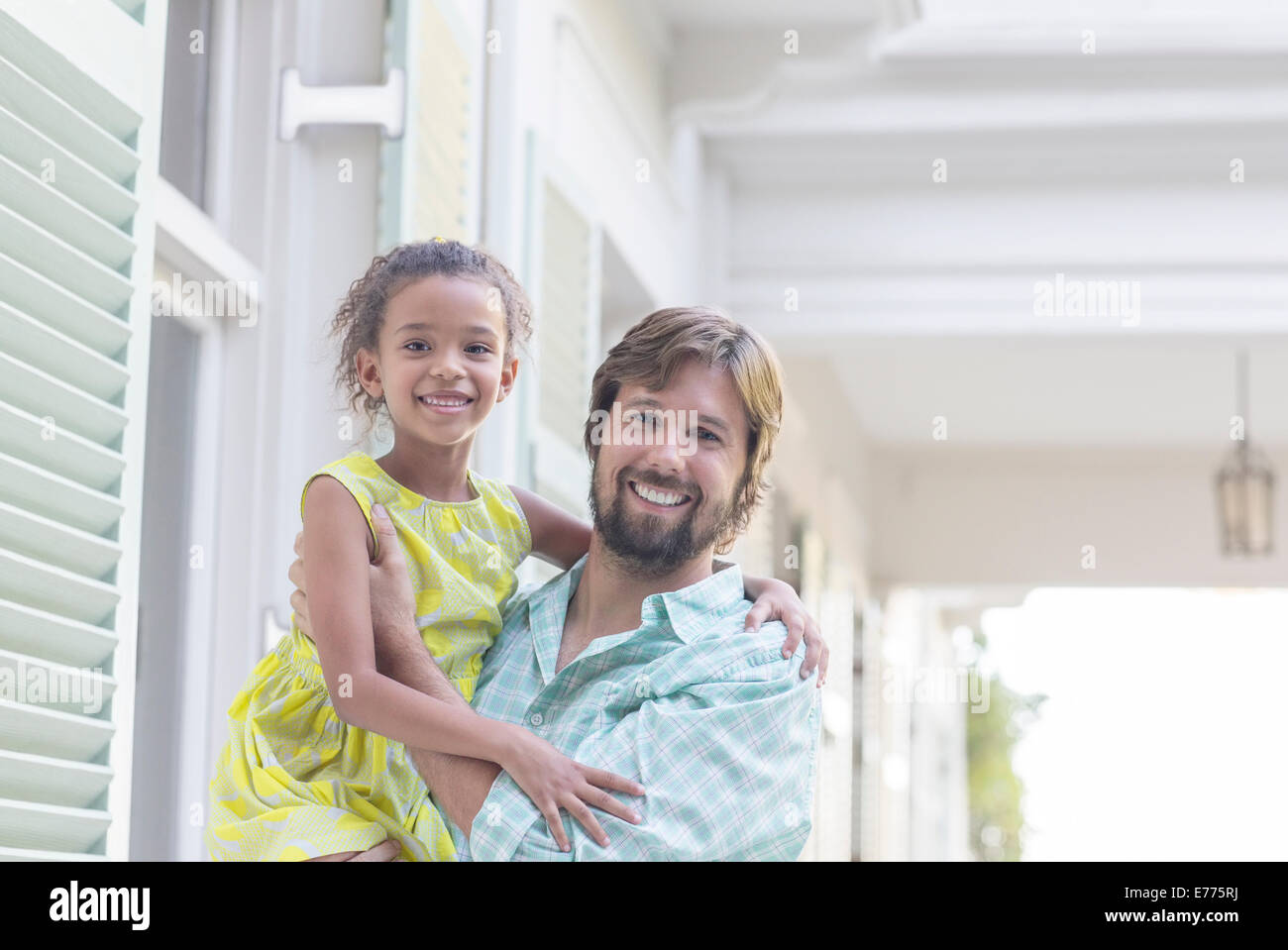 Père holding daughter d'armes à l'extérieur Banque D'Images